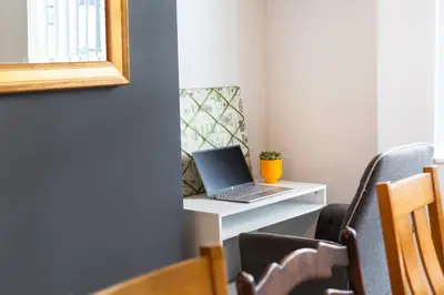 a laptop computer sitting on a white desk at 4 Bedrooms Spacious House With 2 Bathrooms Free Parking - sleeps up to 10 guests in Liverpool