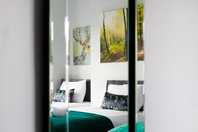 a room with a bed and paintings on the wall at 4 Bedrooms Spacious House With 2 Bathrooms Free Parking - sleeps up to 10 guests in Liverpool