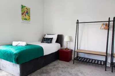 a white bedroom with a bed and a lamp at 4 Bedrooms Spacious House With 2 Bathrooms Free Parking - sleeps up to 10 guests in Liverpool