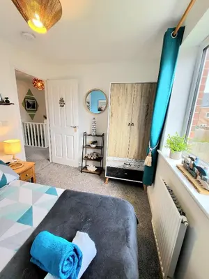 a bedroom with a bed with a blue towel on it at Seaside beach themed home with garden and driveway in Lytham St Annes