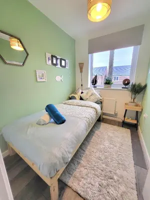 a bedroom with a large bed with a window at Seaside beach themed home with garden and driveway in Lytham St Annes
