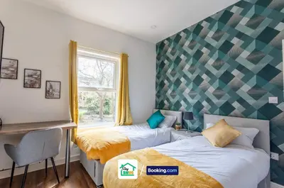 a bedroom with two beds and a desk and a window at Three Bedroom House in Preston in Preston