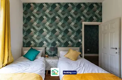 a bedroom with two beds and a geometric wall at Three Bedroom House in Preston in Preston