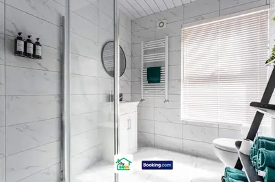 a white bathroom with a shower and a toilet at Three Bedroom House in Preston in Preston