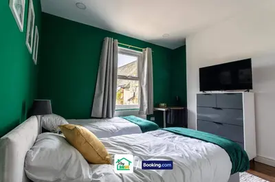 a green bedroom with two beds and a window at Three Bedroom House in Preston in Preston