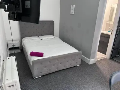 a bed in a room with a purple pillow on it at Triple room Private Bath Near LFC Free Street Parking No Breakfast in Liverpool