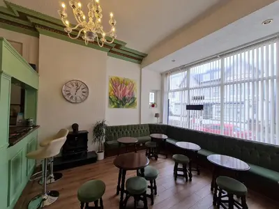 a waiting room with tables and chairs and a clock at Beverley Dean - Children Over 5 Years Welcome - Continental Breakfast in Blackpool