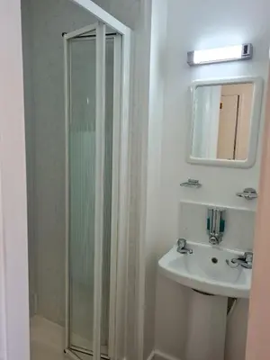 a bathroom with a shower and a sink and a mirror at Beverley Dean - Children Over 5 Years Welcome - Continental Breakfast in Blackpool