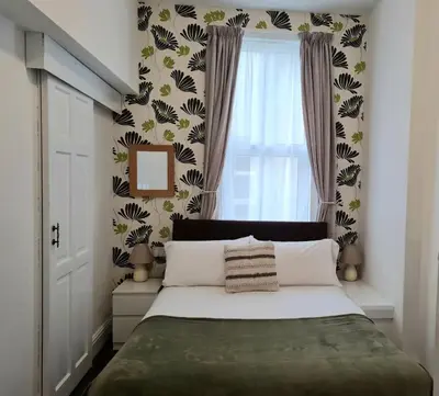 a bedroom with a large bed with a window at Beverley Dean - Children Over 5 Years Welcome - Continental Breakfast in Blackpool
