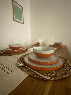 a table with plates and bowls on a wooden table at Cosy home close to M6 motorway in Pemberton