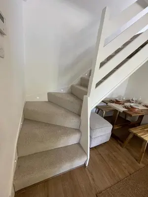 a white staircase in a room with a table at Cosy home close to M6 motorway in Pemberton