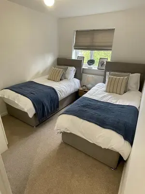 two beds in a small bedroom with a window at Cosy home close to M6 motorway in Pemberton