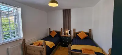 two twin beds in a room with a window at The Hideaway ll private garden Quiet Central in Southport