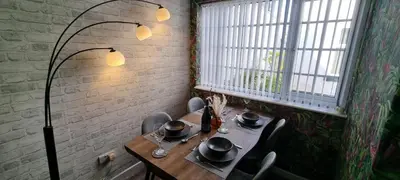 a dining room with a table and chairs and a window at The Hideaway ll private garden Quiet Central in Southport