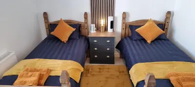 two beds sitting next to each other in a bedroom at The Hideaway ll private garden Quiet Central in Southport