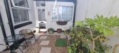 a small patio with plants in front of a house at The Hideaway ll private garden Quiet Central in Southport