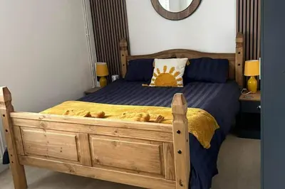 a bedroom with a wooden bed and a mirror at The Hideaway ll private garden Quiet Central in Southport