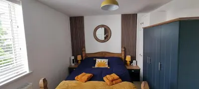 a bedroom with a blue bed and a mirror at The Hideaway ll private garden Quiet Central in Southport