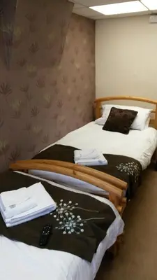 two beds in a hotel room with towels on them at The Manuela Rose in Blackpool