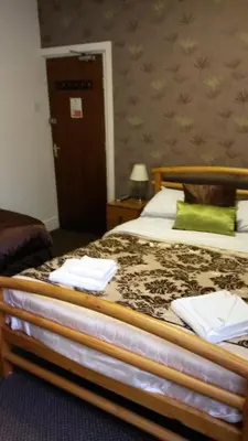 a bedroom with a large bed with green pillows at The Manuela Rose in Blackpool