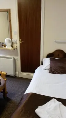 a dog sitting on a bed in a hotel room at The Manuela Rose in Blackpool