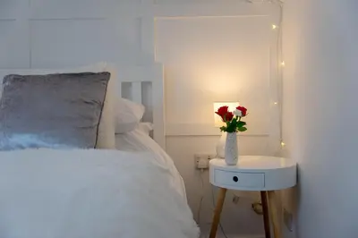 a bedroom with a bed with a vase with roses in it at Kirkmoor Cottage - Cosy home central Clitheroe in Clitheroe