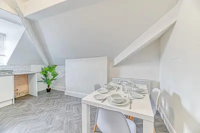 a white dining room with a white table and chairs at Fairhaven View by Guestz in Lytham St Annes