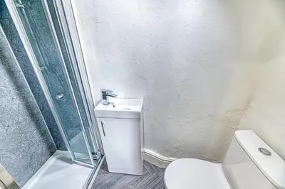 a bathroom with a shower and a toilet and a sink at Fairhaven View by Guestz in Lytham St Annes