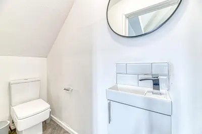 a white bathroom with a sink and a mirror at Fairhaven View by Guestz in Lytham St Annes