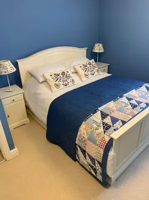 a blue bedroom with a bed with pillows on it at TOPC - Old Posthouse Flat in Garstang