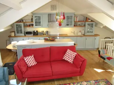 a living room with a red couch in a kitchen at TOPC - Old Posthouse Flat in Garstang