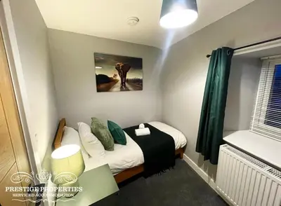 a small room with a bed with a green curtain at Orange View by Prestige Properties SA in Haverigg