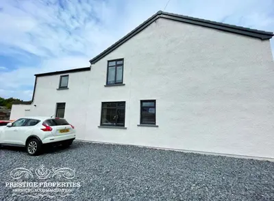 a white house with a car parked in front of it at Orange View by Prestige Properties SA in Haverigg