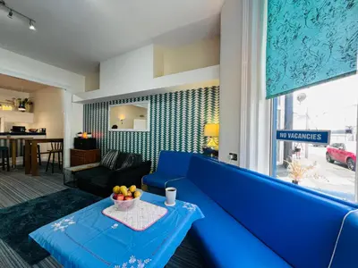 a living room with a blue couch and a table at Tower Central hotel Albert Road in Blackpool