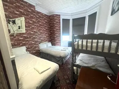 a room with two bunk beds and a brick wall at Tower Central hotel Albert Road in Blackpool