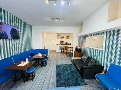a restaurant with blue couches and tables and a kitchen at Tower Central hotel Albert Road in Blackpool