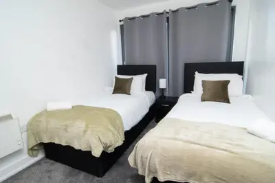 two beds in a room with white walls at 2 bed 2 bath city centre sleep 7 in Liverpool