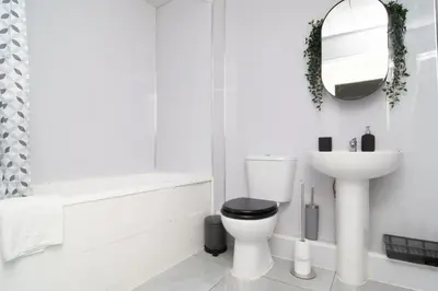 a white bathroom with a toilet and a sink at 2 bed 2 bath city centre sleep 7 in Liverpool