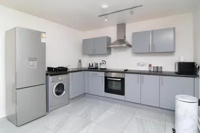 a kitchen with white cabinets and a washer and dryer at 2 bed 2 bath city centre sleep 7 in Liverpool