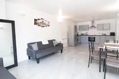 a living room with a couch and a table and a kitchen at 2 bed 2 bath city centre sleep 7 in Liverpool
