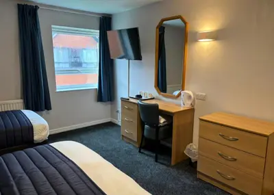 a hotel room with a bed desk and a mirror at Britannia Hotel Wigan in Standish