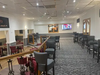 a waiting room with chairs and a tv on the wall at Britannia Hotel Wigan in Standish