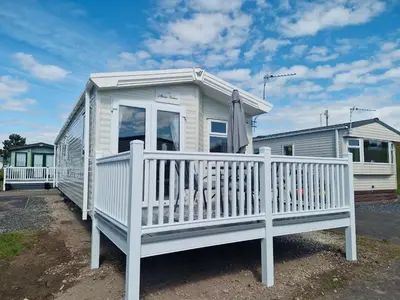 a white tiny house with a white fence at Willaby skye in Heysham
