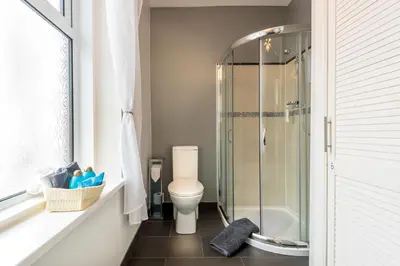 a bathroom with a toilet and a glass shower at Glen Guest House in Blackpool