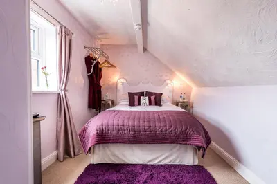 a bedroom with a purple bed in a attic at Glen Guest House in Blackpool