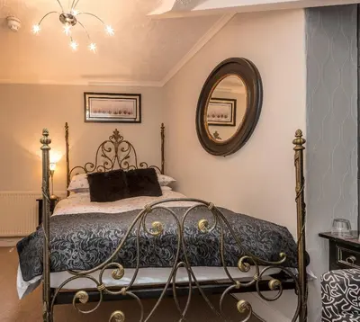 a bedroom with a bed and a mirror at Glen Guest House in Blackpool