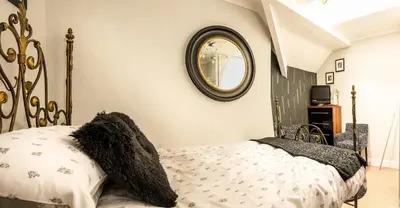 a bedroom with a bed with a large clock on the wall at Glen Guest House in Blackpool