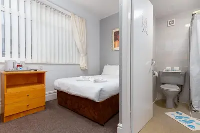 a small bedroom with a bed and a toilet at The Sandringham Court Hotel & Apartment Welcoming Large and Small Groups for 16 years in Blackpool