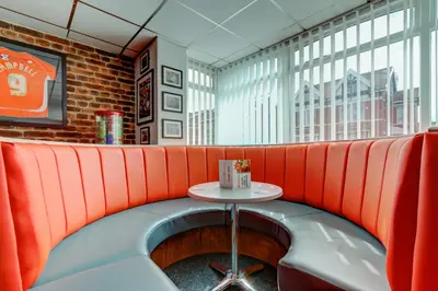 a red booth in a restaurant with a table at The Sandringham Court Hotel & Apartment Welcoming Large and Small Groups for 16 years in Blackpool