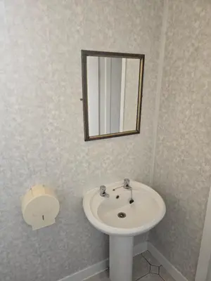 a bathroom with a white sink and a mirror at Wilsons Lodge in Blackpool